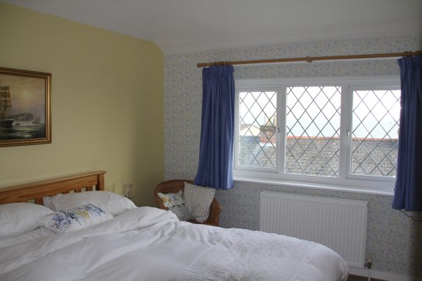 Bedroom 1 with leaded window and blue curtains